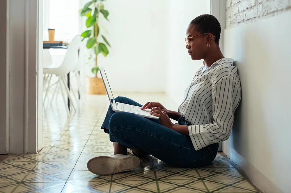 woman-sitting-in-hallway-on-laptop