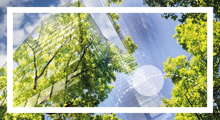 A look up to a steel and glass building with trees imposed on them